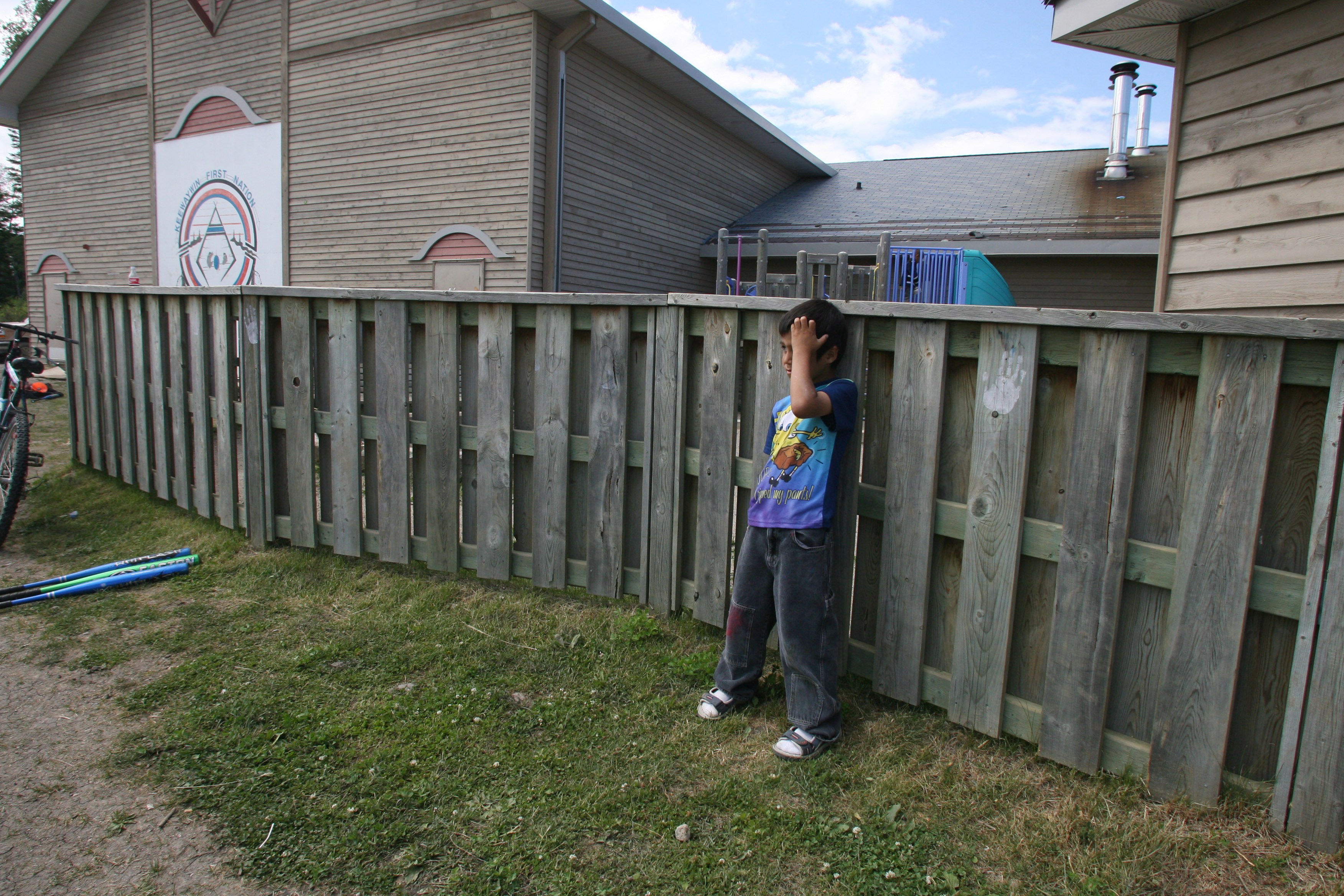 NATIONAL POST STAFF PHOTO // 072007-Toronto- Landon Kakegamic (left), 6, leans on a fence while watching a game of baseball at KeeWayWin, a First Nations community in Northern Ontario, Thursday July 20, 2006. Bartleman was visiting two fly-in First National reserves, Sachigo Lake and KeeWayWin in northern Ontario, to monitor the success of summer literacy camps that he set up to promote literacy and education. STAFF PHOTO: (Tyler Anderson/National Post)